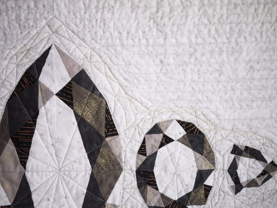 Quilt with geometric diamond pattern on a textured white background