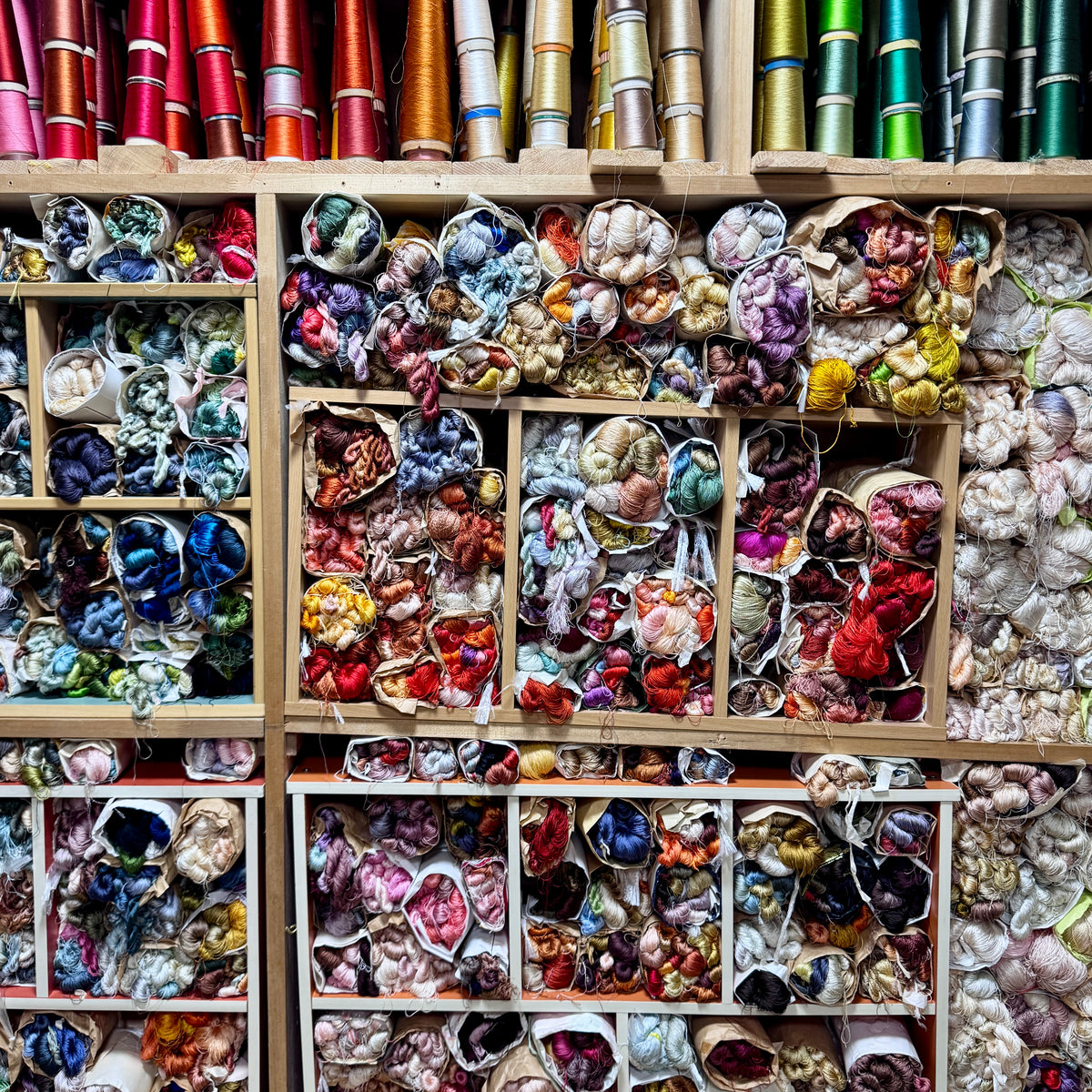 Shelves filled with colorful fabric swatches and spools of thread.