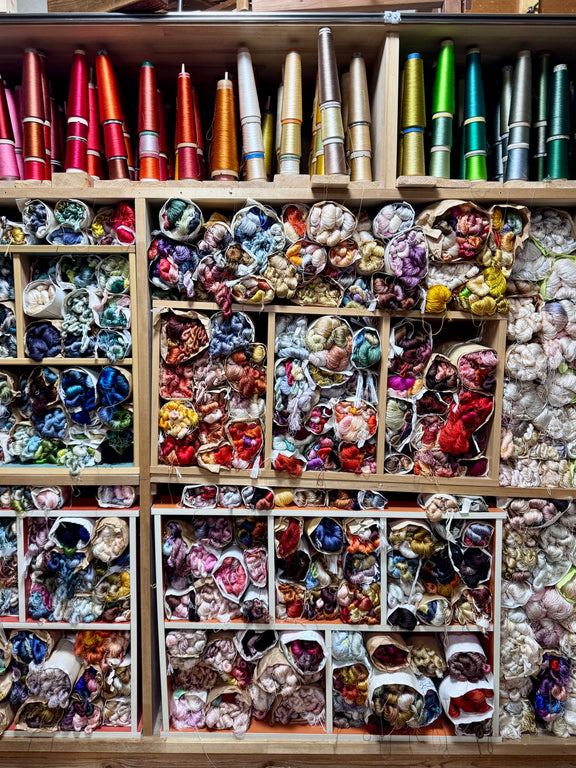 Shelves filled with colorful fabric swatches and spools of thread.