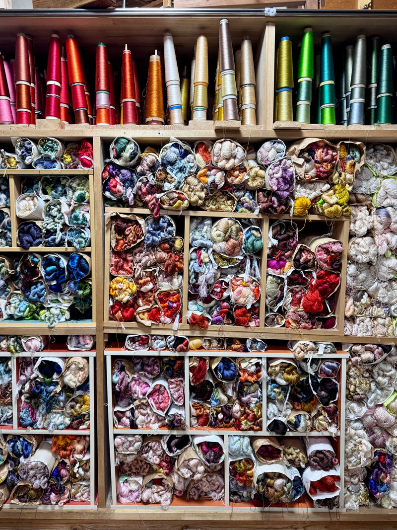 Shelves filled with colorful fabric swatches and spools of thread.